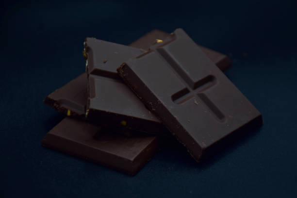 istock Broken chocolate pieces and chocolate chip on black background. 1358502684