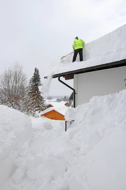 istock A man shovels dangerously heavy snow from a house roof 1358503599