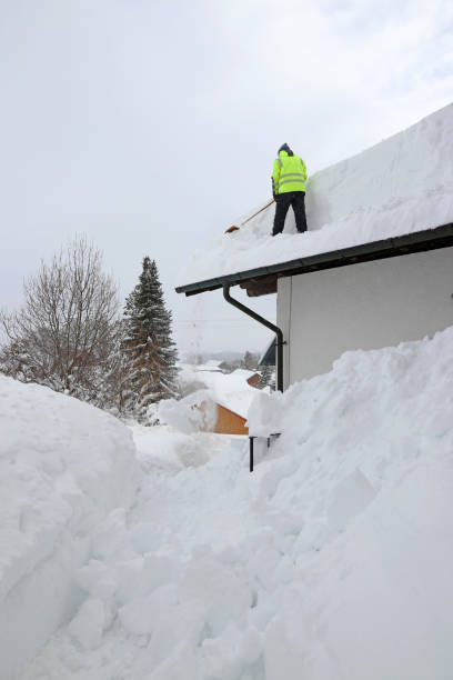 istock A man shovels dangerously heavy snow from a house roof 1358504170