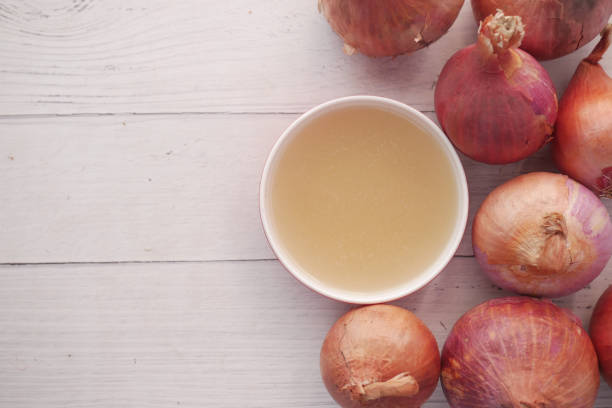 red inion water in a container on table close up red inion water on table with copy space . onion family stock pictures, royalty-free photos & images