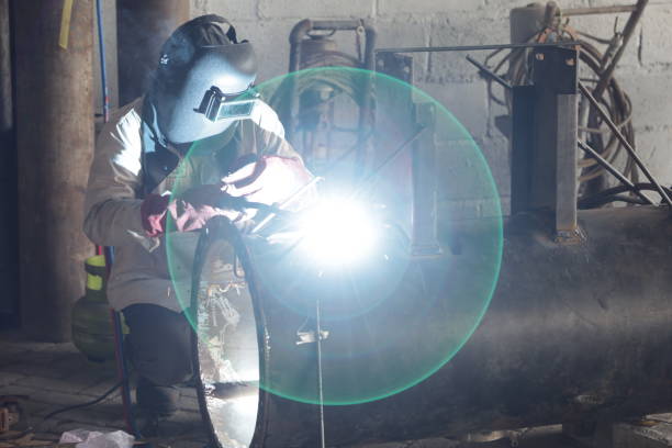 istock welder welding steel with complete safety wear 1358504462