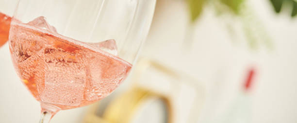 duas taças de rosa acendendo vinho em casa - rosé - fotografias e filmes do acervo
