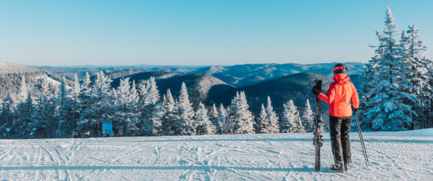 narciarka narciarka patrząc na góry krajobraz przyrody na zewnątrz stojąc trzymając narty. narciarstwo alpejskie na białych stokach śnieżnych w chłodne dni na idyllicznym banerze widokowym. sporty zimowe w kanadzie. - skiing winter sport powder snow athlete zdjęcia i obrazy z banku zdjęć