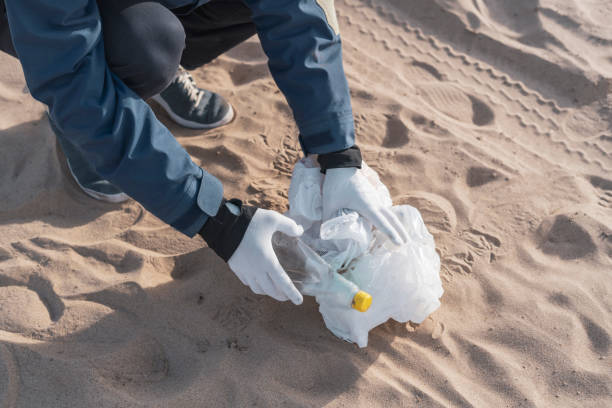 istock global environment problems conversation, person holding garbage outdoors, cleaning our ecosystem 1358509614