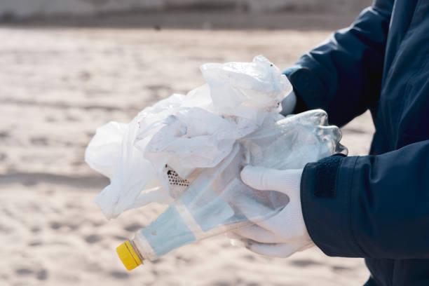 istock global environment problems conversation, person holding garbage outdoors, cleaning our ecosystem 1358509617