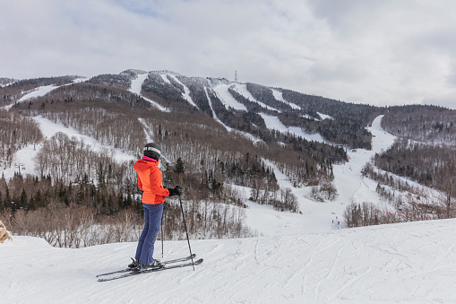 Blue and white mountain skis, sunscreen mask or ski goggles and ski boots lie on bright alpine snow. Alpine ski equipment on snow