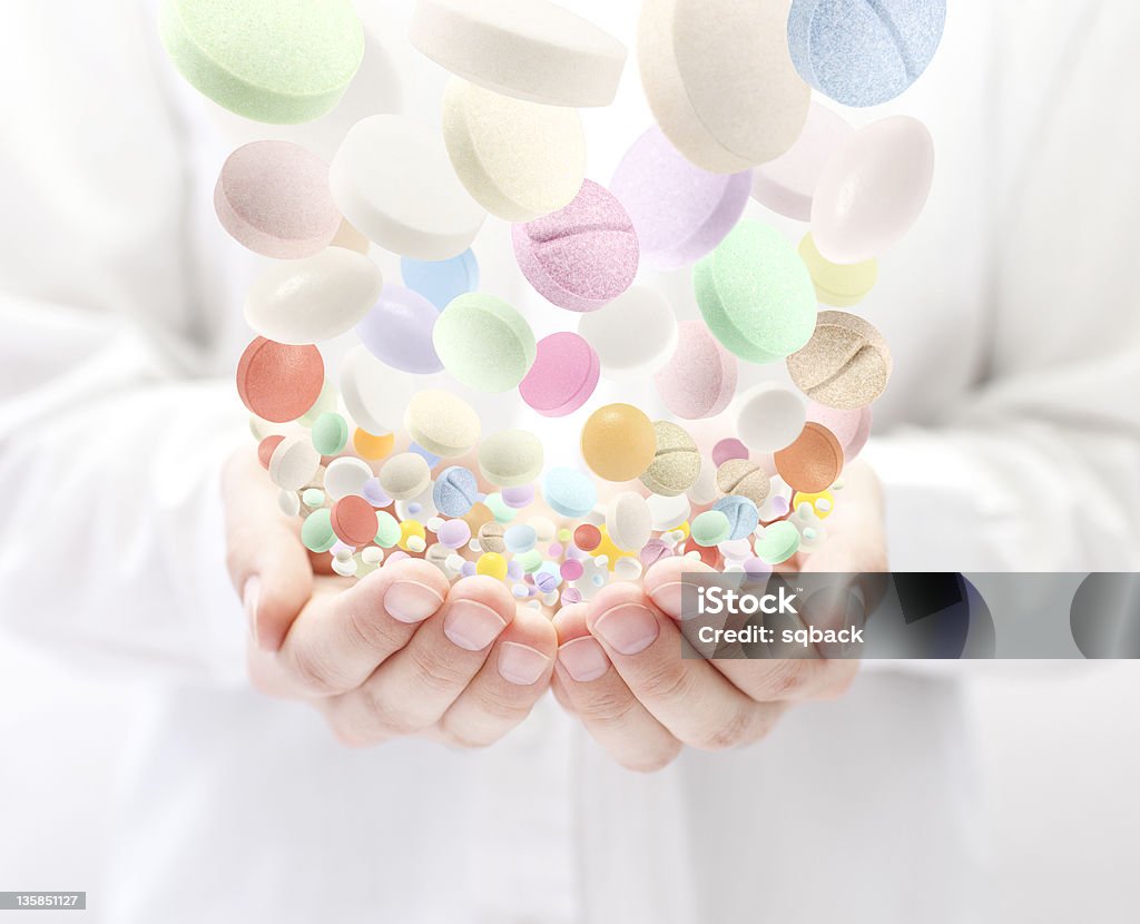 Colorful pills falling into open palms Addiction Stock Photo