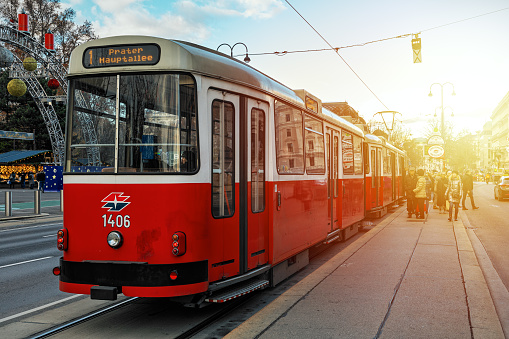 Vienna, Austria - December 03, 2019: Old fashioned red tram at the stop on the street of Vienna - capital and largest city of Austria.