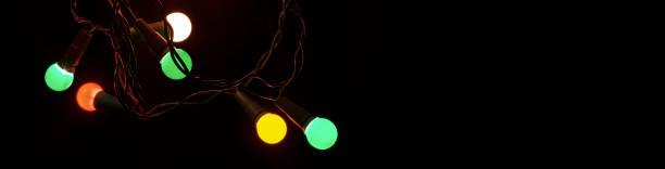 istock Christmas glowing colorful lights on black background. Selective focus. New Year, decor and holiday concept photo. 1358533257