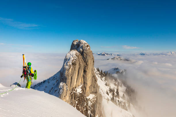 istock Mountaineer man climbs on top snowy mountain with Ski at the backpack 1358535272