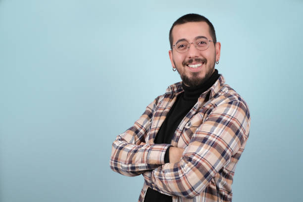 istock happy young man dressed in hipster style stands in front of blue backdrop 1358541238