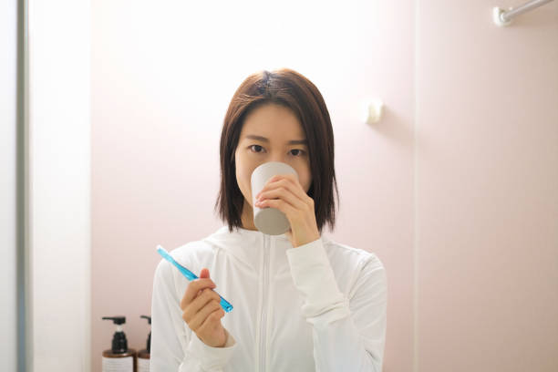 istock Woman brushing teeth in bathroom 1358543595