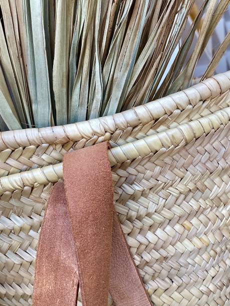 Close Up Part of Wicker and Leather Basket Vertical close up of hand waves wicker platted beige natural material basket with leather strap moses basket stock pictures, royalty-free photos & images