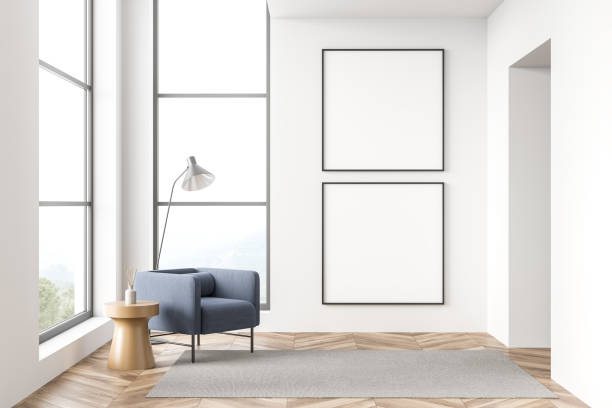 istock Two empty canvases in white hall with single blue armchair 1358547751