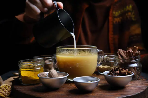 Making spicy turmeric chai latte