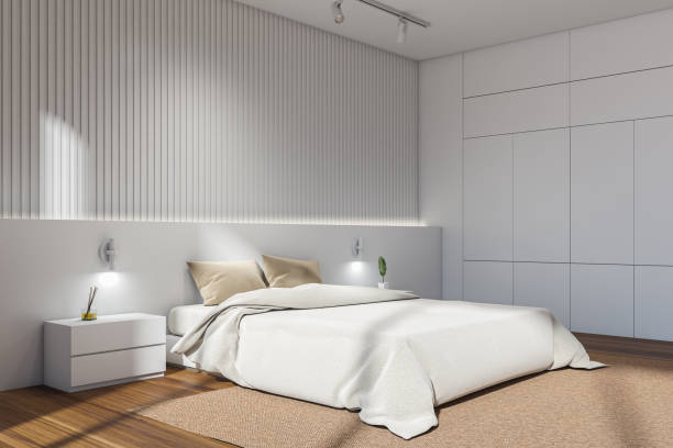 istock White bedroom interior with bed on carpet, nightstand with decoration 1358549162