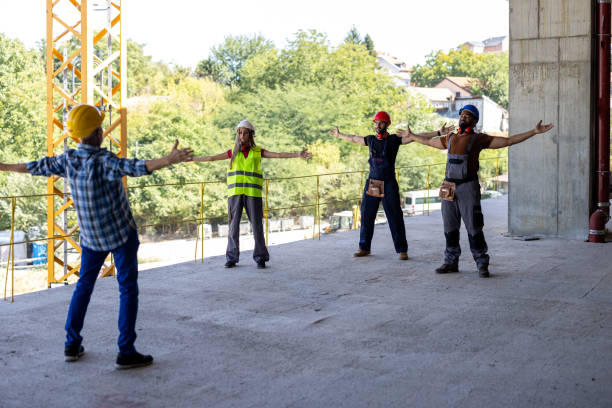 istock Four Workers of Different Ethnicities are Exercising at the Building Site. 1358549174