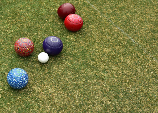 Some colored lawn bowls clustered around the white ball known as the jack