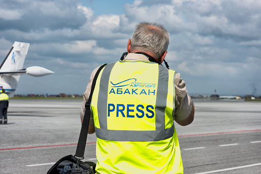 Abakan, Russia - August 08, 2020: a press photographer waiting for an aircraft landing at the airport.
