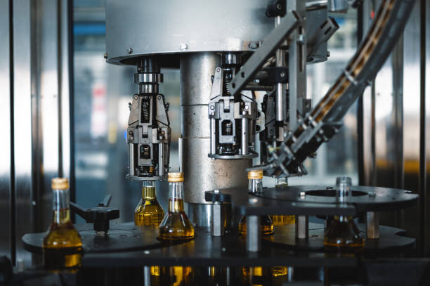 istock Machine tool puts caps on bottles of hard alcohol drink 1358553626