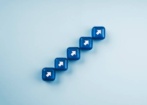 istock White rising arrows, increase symbol on blue cube blocks stacking as a chart step stair on a light blue background, top view. Business growth, profit, and success process concept, minimal style. 1358557417
