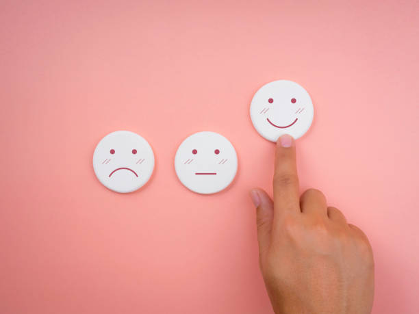 istock Customer service evaluation, ratings, feedback, client experience, and satisfaction survey concepts. Hand pointing at happy smile face on white round sponge on pink pastel background. 1358557486