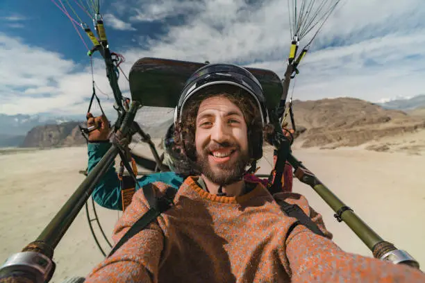 Selfie of young Caucasian man paramotor flying over Katpana Desert in Northern Pakistan