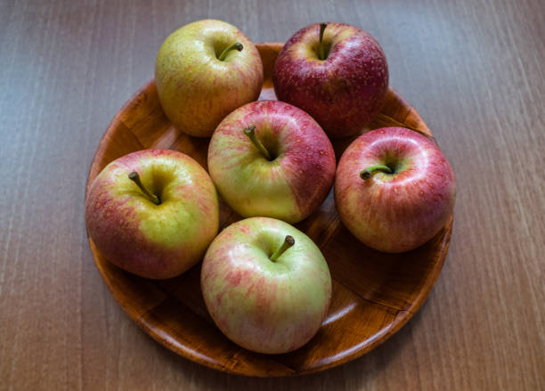 istock Several apples on a plate and wooden table 1358561526