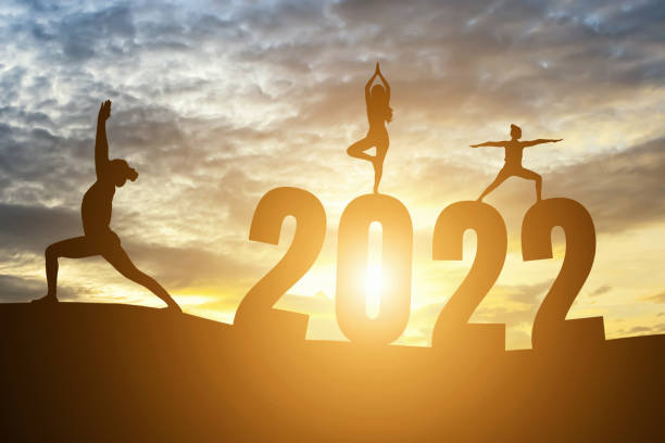 с новым годом номера 2022, силуэт женщины, практикующей йогу ранним утром восход солнца над горизонтом фон, здоровье и концепция счастливого � - yoga challenge for 3 стоковые фото и изображения