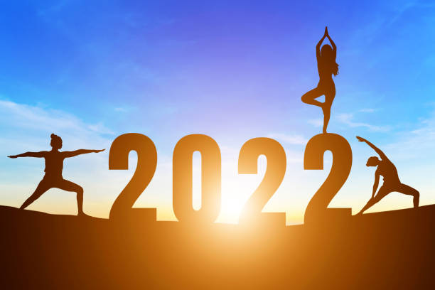 с новым �годом номера 2022, силуэт женщины, практикующей йогу ранним утром восход солнца над горизонтом фон, здоровье и концепция счастливого � - yoga challenge for 3 стоковые фото и изображения