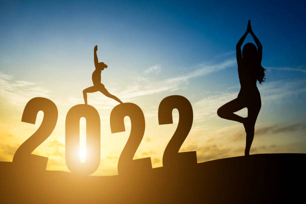 с новым годом номера 2022, силуэт женщины, практикующей йогу ранним утром восход солнца над горизонтом фон, здоровье и концепция счастливого � - yoga challenge for 3 стоковые фото и изображения