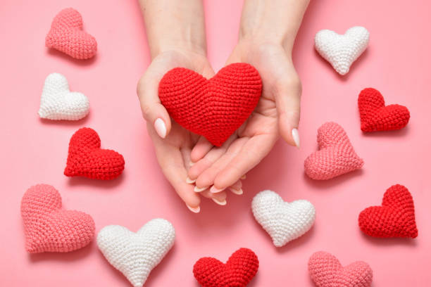 istock Women's hands hold a red knitted heart. Background for Valentine's Day. 1358565601