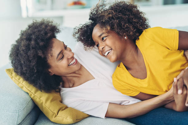 istock Happy mother and daughter playing on the couch 1358566619