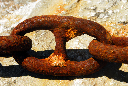 Close-up of a rusty chain connected to a rusty tube on a shipyard. With copy space. Shot with a 35-mm full-frame 61MP Sony A7R IV.