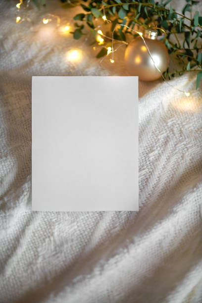 istock Christmas empty 5x7 card mockup with gift, eucaliptus leaves and light garland on a knitted beige background 1358566919