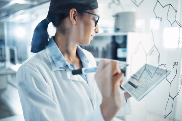 istock Shot of a young scientist solving equations on a glass screen in a laboratory 1358567680