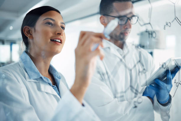 istock Shot two a young scientists solving equations on a glass screen in a laboratory 1358567874