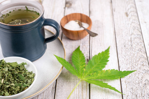 cannabis tea with cup and tea strainer - cannabis, marijuana - photography sign table ganja imagens e fotografias de stock