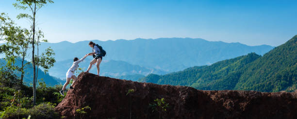 istock Asian hiking help each other on mountains 1358572437