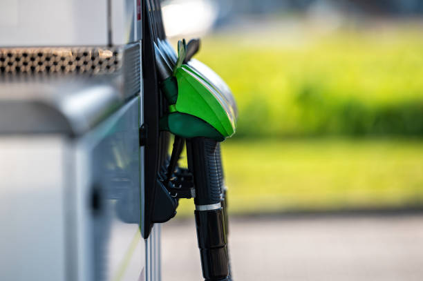 reihe mit grünen und schwarzen betankungspistolen an der tankstelle, nahaufnahme, horizontalschuss - fuel pomp stock-fotos und bilder