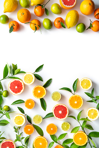 Collection of whole and sliced citrus fruits isolated on white background. The composition includes grapefruit, orange, lemon, lime, tangerine and kumquat. Some citrus tree leaves complete the composition. High resolution 42Mp studio digital capture taken with Sony A7rii and Sony FE 90mm f2.8 macro G OSS lens