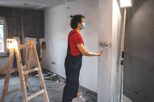 istock Construction worker painting apartment walls 1358574662