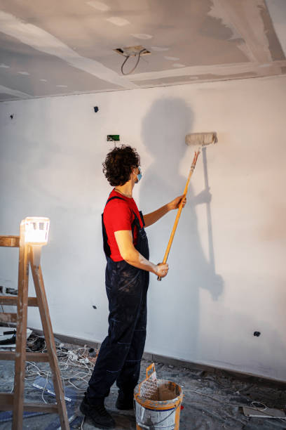istock Construction worker painting apartment walls 1358574799