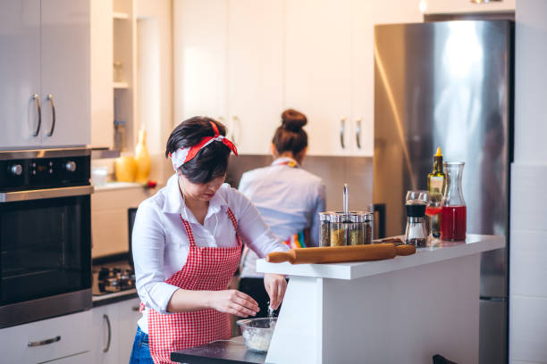 istock Two Young Women Baking In The Kitchen 1358576326