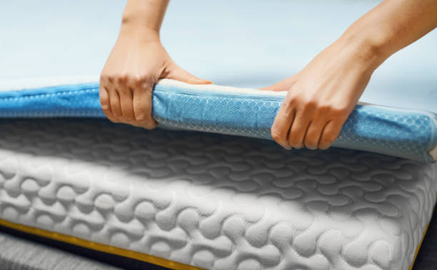 istock Woman hand testing orthopedic memory foam mattress topper. 1358576428