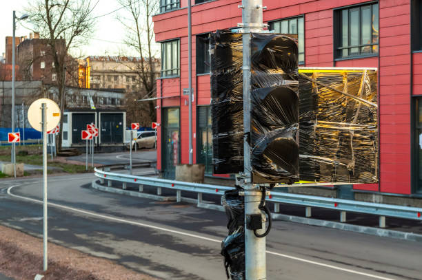 istock installing traffic lights. the new traffic light is wrapped in black plastic wrap. 1358580073