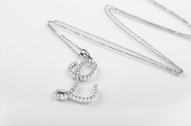 istock Silver necklace with a diamond pendant on white background. 1358581306