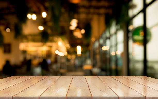 istock Empty wooden table top with lights bokeh on blur restaurant background. 1358582170