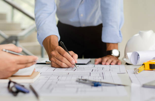 istock Engineer who is planning a draft of the structure. With architect equipment and team discussions about architectural blueprints at desks in modern offices. 1358582915