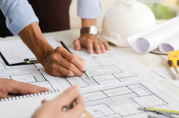 Photo of Close-up of an engineer planning a hand-drawn design. with architect equipment Architects talking at the table Teamwork and workflow concepts
